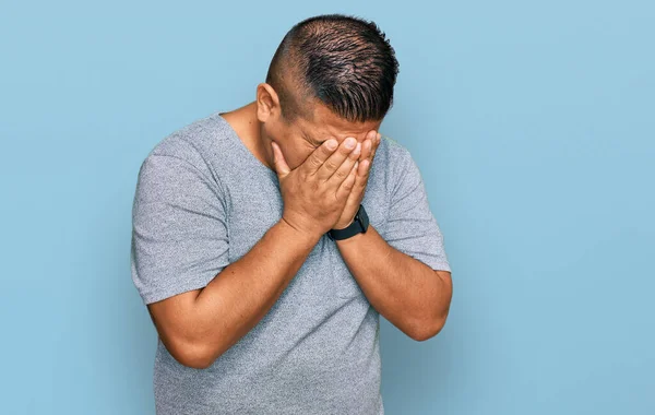 年轻的拉丁男子穿着休闲装 脸上挂着忧郁的表情 一边哭一边用手捂住脸 抑郁症的概念 — 图库照片