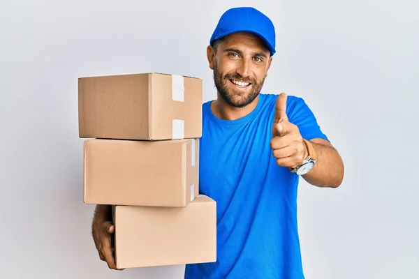 Handsome Man Beard Wearing Courier Uniform Holding Delivery Packages Pointing — Stock Photo, Image