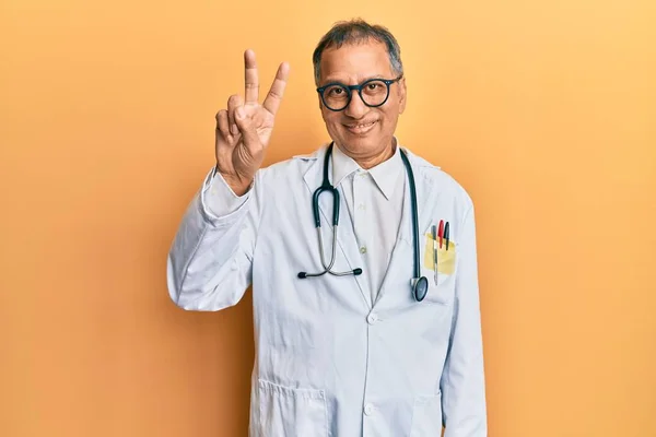 Hombre Indio Mediana Edad Vistiendo Abrigo Médico Estetoscopio Mostrando Señalando —  Fotos de Stock