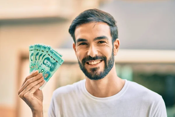 Fiatal Spanyol Férfi Mosolyog Boldog Kezében Kínai Jüan Bankjegyek Városban — Stock Fotó