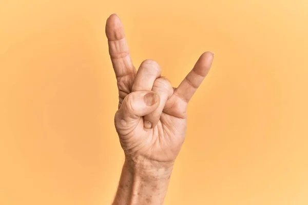Senior Kaukasischen Hand Über Gelben Isolierten Hintergrund Gestikuliert Rock Roll — Stockfoto