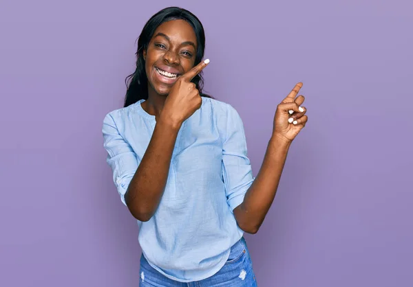Młoda Afroamerykanka Luźnych Ciuchach Uśmiechnięta Patrząca Kamerę Dwiema Rękami Palcami — Zdjęcie stockowe