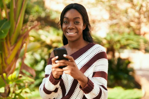 Joven Mujer Afroamericana Sonriendo Feliz Usando Smartphone Parque —  Fotos de Stock