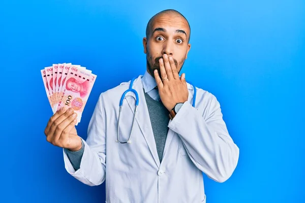 ヒスパニック系の成人医師の男性の手で口をカバー元の紙幣を保持医療制服を着てショックを受け ミスを恐れている 驚きの表情 — ストック写真