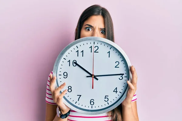 Young Brunette Woman Holding Big Clock Covering Face Shock Face — 스톡 사진