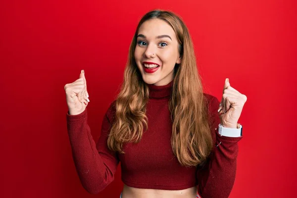 タートルネックのセーターを着た若いブロンドの女性は驚きを祝い 腕を上げて目を開けて成功したことに驚いています 勝者のコンセプト — ストック写真