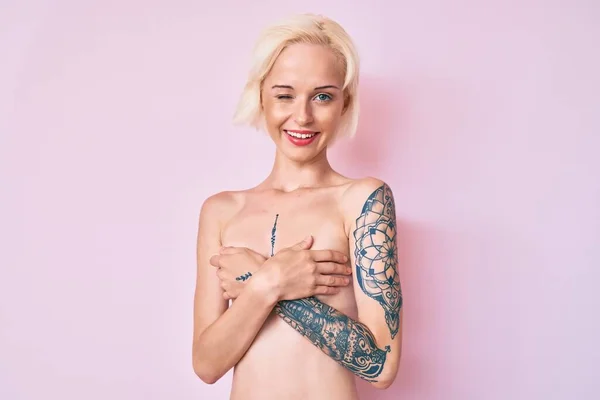 Ung Blondine Kvinde Med Tatovering Stående Shirtless Blinker Ser Kameraet - Stock-foto