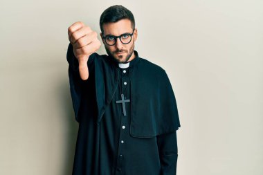 Beyaz arka plan üzerinde duran İspanyol üniformalı genç adam mutsuz ve kızgın görünüyor. Reddedilmiş ve olumsuz. kötü ifade. 