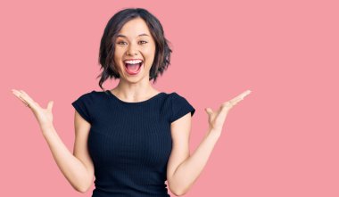 Genç ve güzel bir kız gündelik giysiler içinde zaferi mutlu bir gülümsemeyle ve kazanan bir ifadeyle kutluyor. 