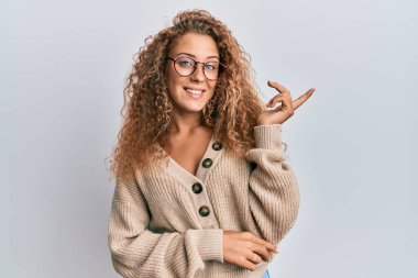 Güzel, beyaz, sıradan kıyafetler ve gözlük takan genç bir kız gülümsüyor. 