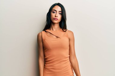 Yazlık elbise giyen güzel İspanyol kadın yüzünde ciddi bir ifadeyle rahatlamış. Basit ve doğal bir şekilde kameraya bakıyorsun.. 