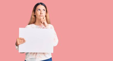 Güzel genç bir kadın boş afiş taşıyordu ciddi bir yüzü vardı eli çenesinde soruyu düşünüyordu, kafa karıştırıcı bir fikirdi. 