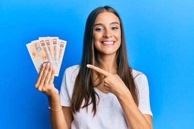 Birleşik Krallık 'ı elinde tutan genç İspanyol kadın mutlu bir şekilde el ve parmağıyla işaret ediyor. 