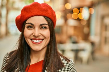 Genç İspanyol kadın gülümseyerek şehirde mutlu mesut dikiliyor..