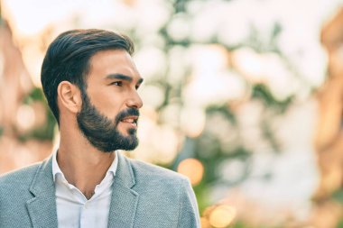 Genç İspanyol işadamı gülümseyerek şehirde mutlu mesut duruyor..