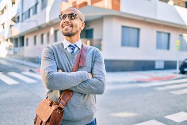 Genç Afrikalı Amerikalı iş adamı gülümseyerek şehirde mutlu bir şekilde yürüyor..