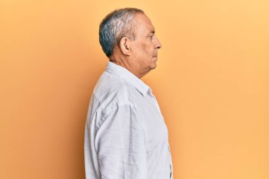 Yakışıklı, beyaz gömlek giyen, rahat bir görünüm takınan, kendine güvenen bir gülümsemesi olan olgun bir adam.. 