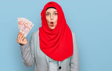 İslamcı başörtüsü takan güzel İspanyol kadın Singapur dolarları tutuyor. Banknotlar. 