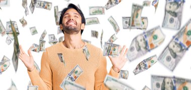 Yakışıklı İspanyol kazak giyen, çılgın ve başarıyı kutlayan kolları havada ve gözleri kapalı heyecanlı çığlıklar atan yakışıklı bir adam. Kazanan konsept