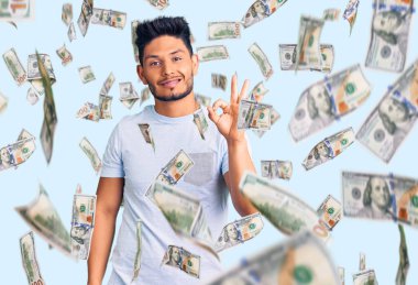 Yakışıklı Latin Amerikalı, günlük kıyafetler giyen, gülümseyen, el ve parmaklarıyla 