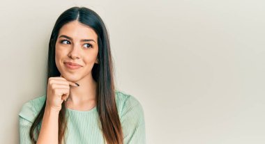 Gündelik kıyafetler giyen genç İspanyol kadın şüphe üzerine yoğunlaşmıştı. Parmakları çenesinde ve yukarı bakıyordu. 