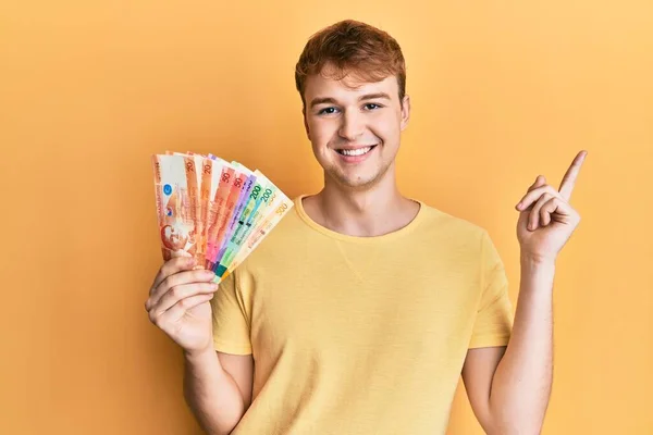 Fiatal Fehér Férfi Kezében Fülöp Szigeteki Peso Bankjegyek Mosolyogva Boldog — Stock Fotó