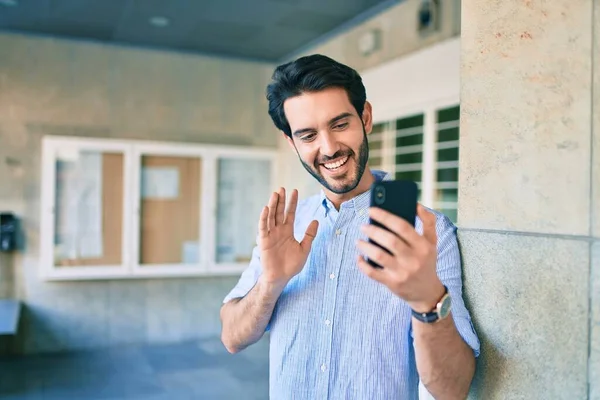 若いですヒスパニック男笑顔幸せな行いビデオ通話を使用してスマートフォンで市 — ストック写真