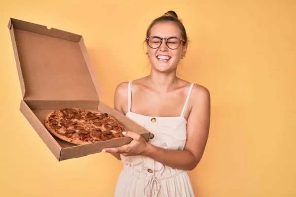 おいしいペパロニピザを保持している美しい白人女性は笑顔と面白いクレイジー冗談ので大声で笑います — ストック写真