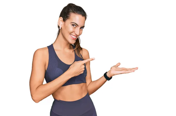 Young Beautiful Woman Wearing Sportswear Amazed Smiling Camera While Presenting — Stock Photo, Image