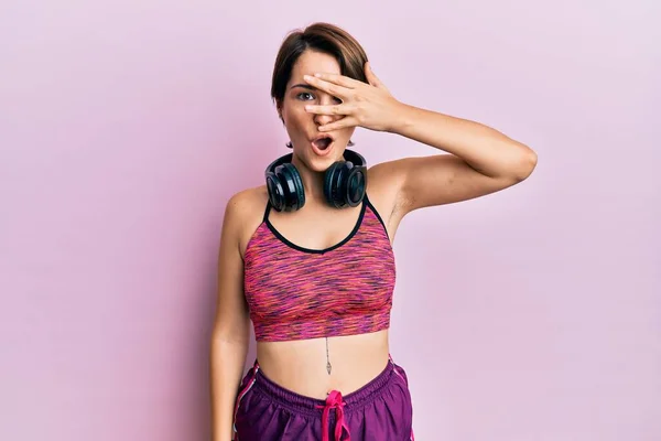 Kısa Saçlı Spor Giysili Kulaklıklı Genç Esmer Kadın Şok Içinde — Stok fotoğraf