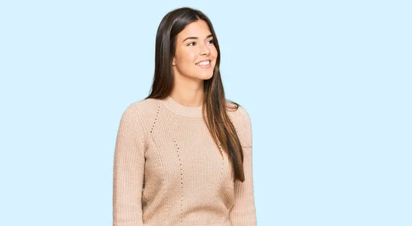 若いブルネットの女性が顔に笑顔で横に見えるカジュアルな冬のセーターを着て 自然な表情 自信を持って — ストック写真