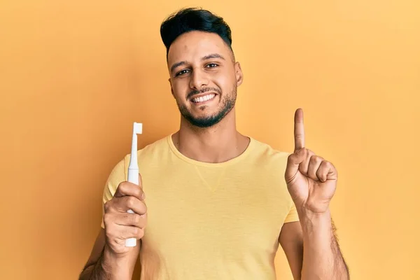 Jeune Homme Arabe Tenant Une Brosse Dents Électrique Souriant Avec — Photo