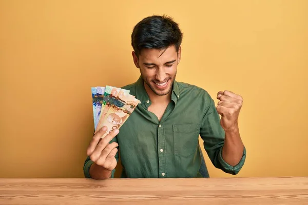 Młody Przystojny Mężczyzna Trzymający Kanadyjskie Dolary Bardzo Szczęśliwy Podekscytowany Wykonując — Zdjęcie stockowe