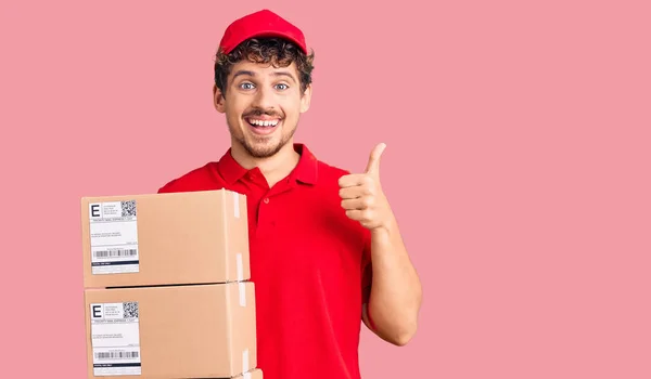 Jovem Homem Bonito Com Cabelo Encaracolado Segurando Pacote Entrega Sorrindo — Fotografia de Stock