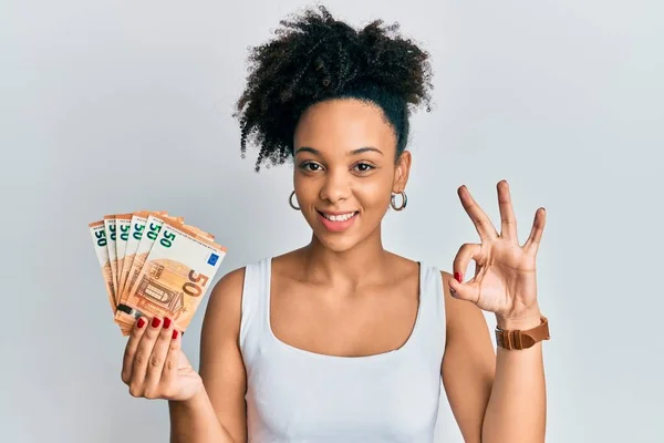 Chica Afroamericana Joven Sosteniendo Billetes Euros Haciendo Signo Con Los —  Fotos de Stock