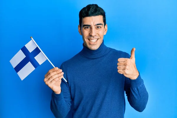 俊俏的惊慌失措的男人举着芬兰队的旗帜 喜形于色 泰然自若 泰然自若 泰然自若 — 图库照片