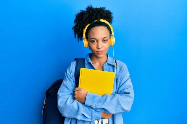 Молода Афроамериканська Дівчина Одягнена Студентський Рюкзак Навушники Тримає Книжки Скептично — стокове фото