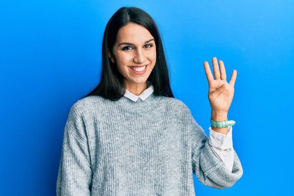 Young hispanic woman wearing casual clothes showing and pointing up with fingers number four while smiling confident and happy. 