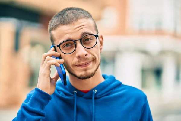 Joven Hombre Hispano Con Expresión Relajada Hablando Smartphone Ciudad —  Fotos de Stock
