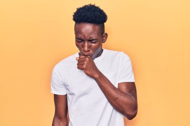 Genç Afro-Amerikalı bir adam günlük giysiler giyiyor kendini iyi hissetmiyor ve soğuk algınlığı veya bronşitin belirtisi olarak öksürüyor. sağlık hizmeti kavramı. 