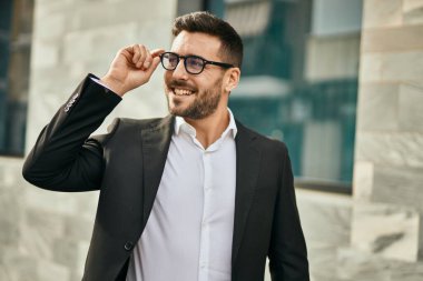 Genç İspanyol işadamı gülümseyerek şehirde mutlu mesut duruyor..