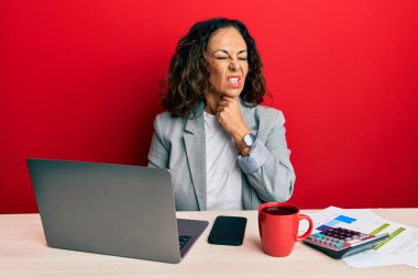 Ofiste çalışan orta yaşlı güzel bir kadın bir fincan kahve içiyor. Ağrılı boynuna dokunuyor. Grip, mantar ve enfeksiyon yüzünden boğazı ağrıyor. 