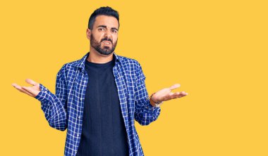 Gündelik giysiler giyen genç İspanyol adam habersiz ve kolları açık, hiçbir fikri yok.. 