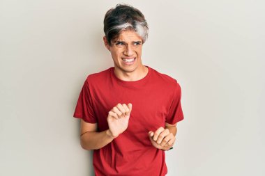 Gündelik kıyafetler giyen genç İspanyol adam tiksindirici bir ifade takınıyor ve tiksindirici bir yüz ifadesi takınıyor.. 