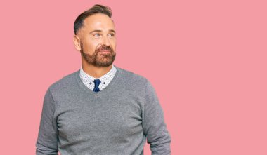 Yakışıklı, orta yaşlı, iş elbiseleri giyen, gülümseyen, yan bakıp düşünen bir adam.. 