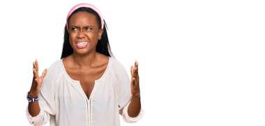 Genç siyahi kadın gündelik kıyafetler giyip deli gibi bağırıyor ve agresif bir ifade ve kollarla bağırıyor. hüsran kavramı. 