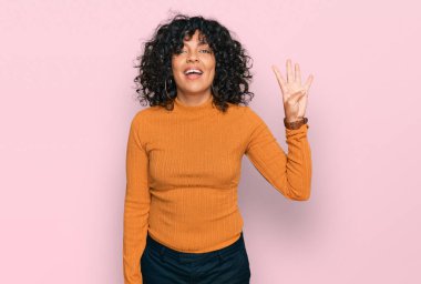 Genç İspanyol kadın gündelik giysiler giyer ve parmaklarını dört numarayı göstererek gülümserken kendinden emin ve mutlu.. 