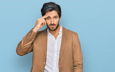 İş kıyafetleri giyen genç İspanyol adam, alnında bir sorun olduğu için endişeli ve stresli, gergin ve bunalımda. 