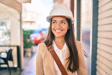 Genç, latin mimar kız gülümseyerek şehirde mutlu mesut duruyor..