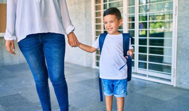 Sevimli Latin öğrenci çocuk ve anne okulda bekliyor..